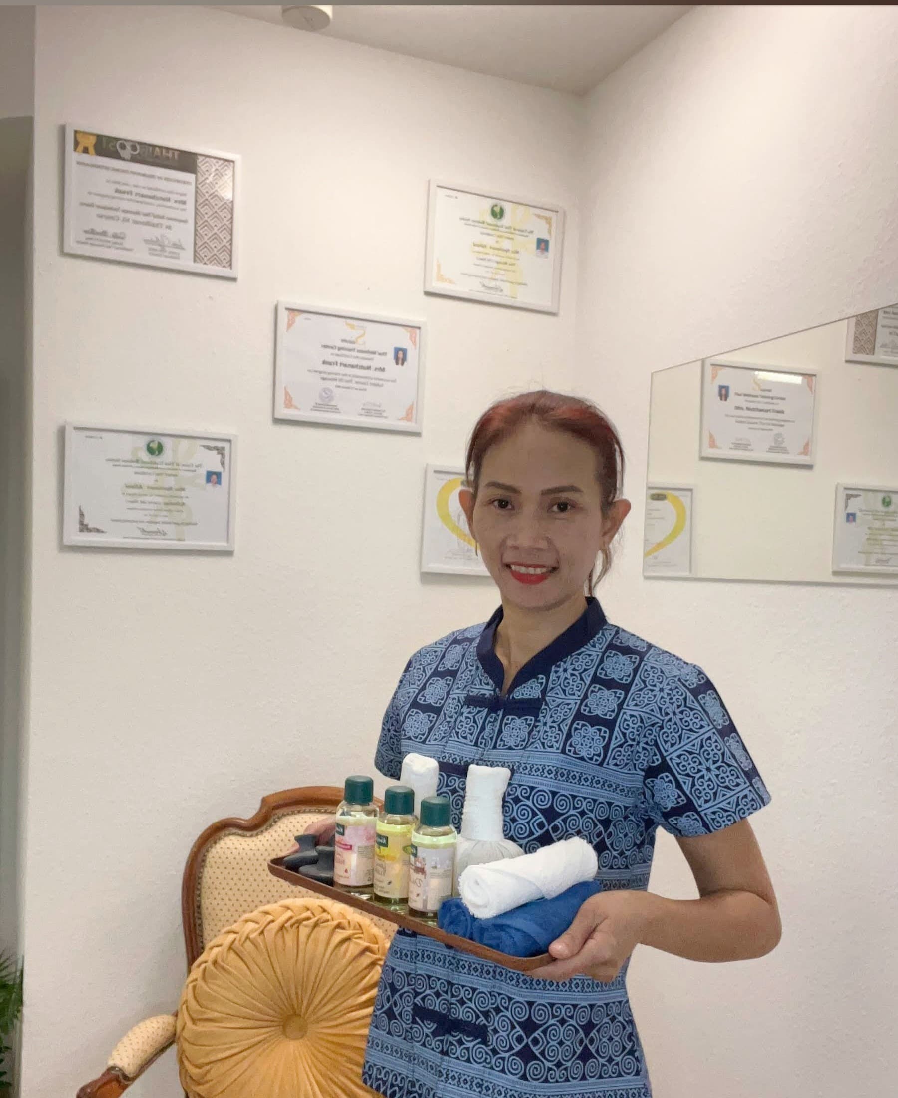 Erfahrene Therapeutin von Relax Spa Thai Massage Liestal vor ihren Zertifikaten und Diplomen